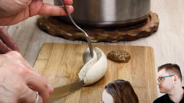 Weißwurst halbieren - die Banane Weißwurst wird mit dem Messer geteilt