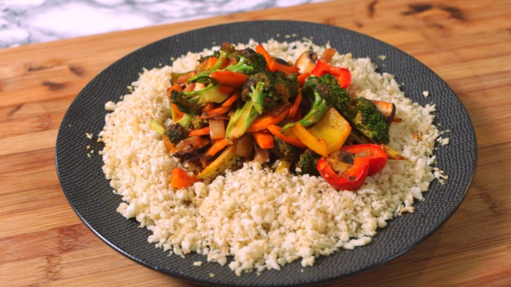 Teller mit Blumenkohlreis und angebratenem Gemüse