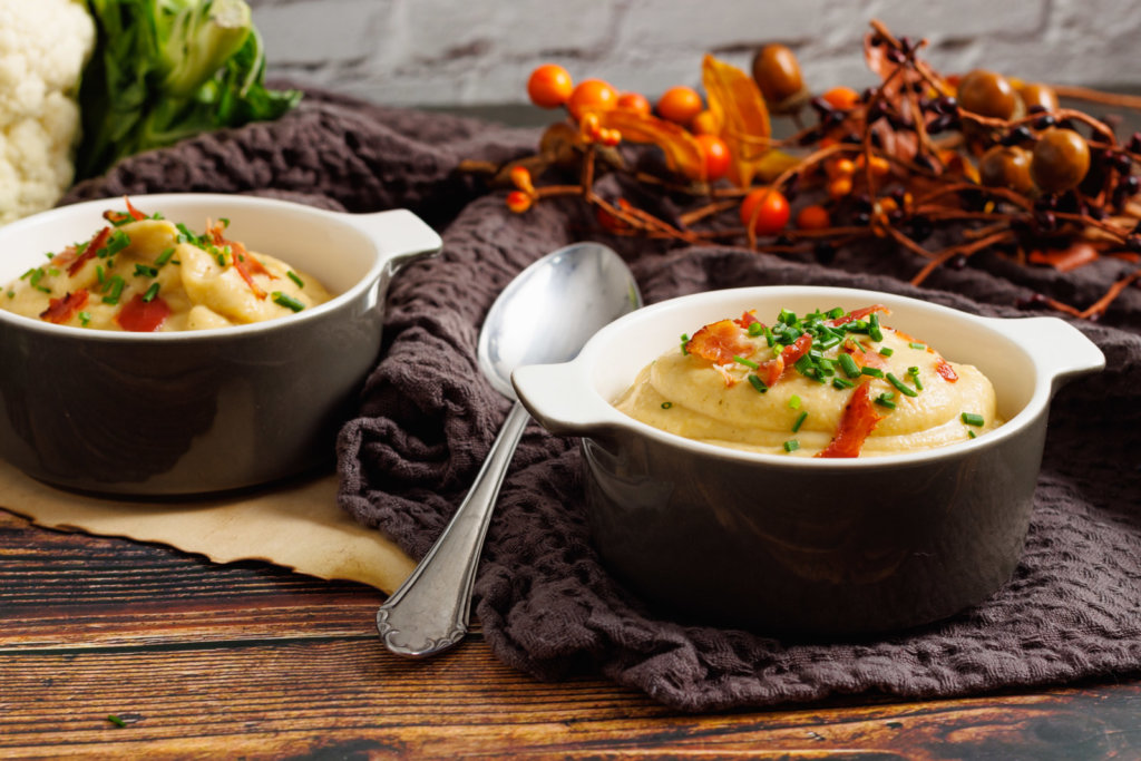 Schüssel mit Blumenkohlsuppe auf dem Tisch dekoriert mit Bacon Brösel