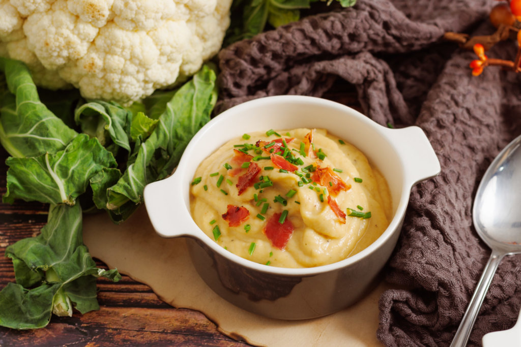 Schüssel mit Blumenkohlsuppe auf dem Tisch dekoriert mit Bacon Brösel