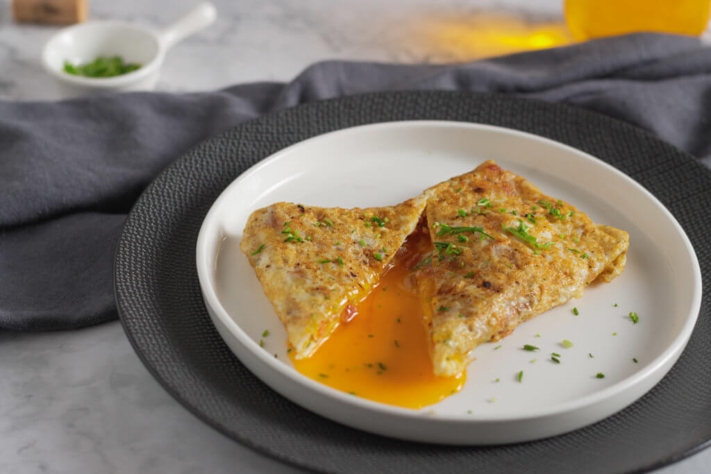 gefaltetes Omelette auf einem weißen Teller