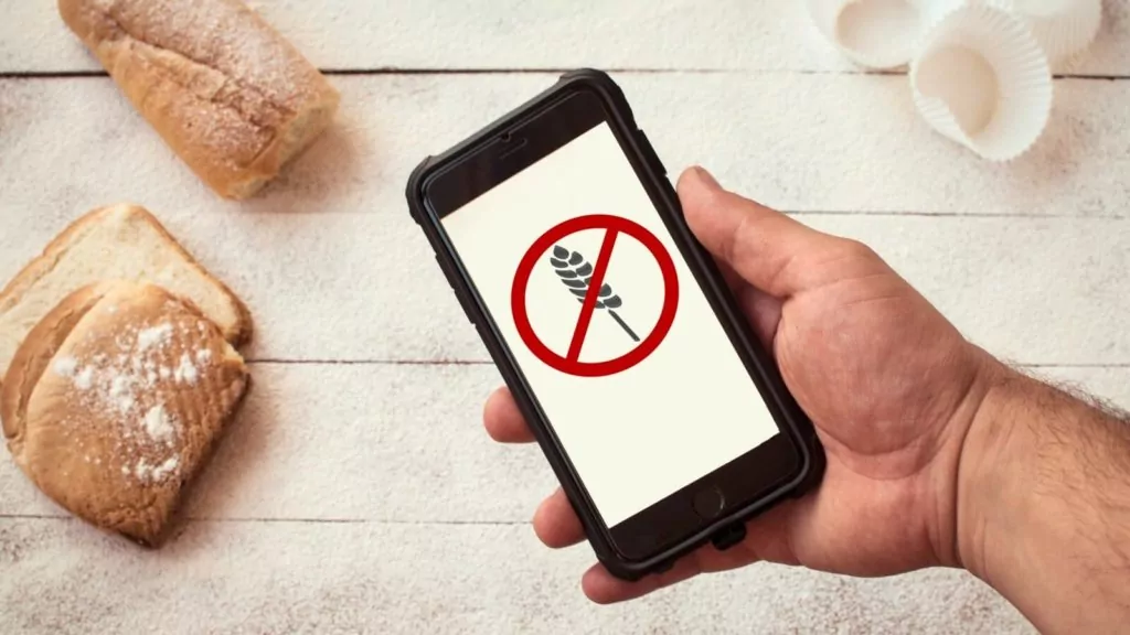 Glutenfreie Ern&auml;hrung. Hand h&auml;lt ein Mobiltelefon