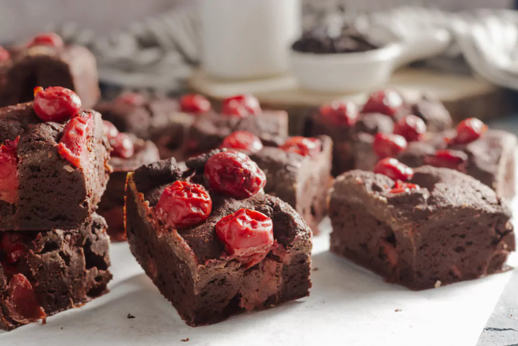 Frisch gebackene Low Carb Schoko-Kirsch-Brownies auf Backpapier