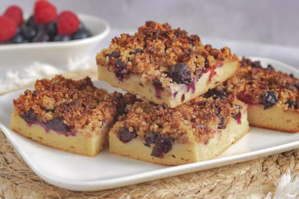 Beeren-Blechkuchen ohne Zucker mit Streusel auf einem weißen Teller