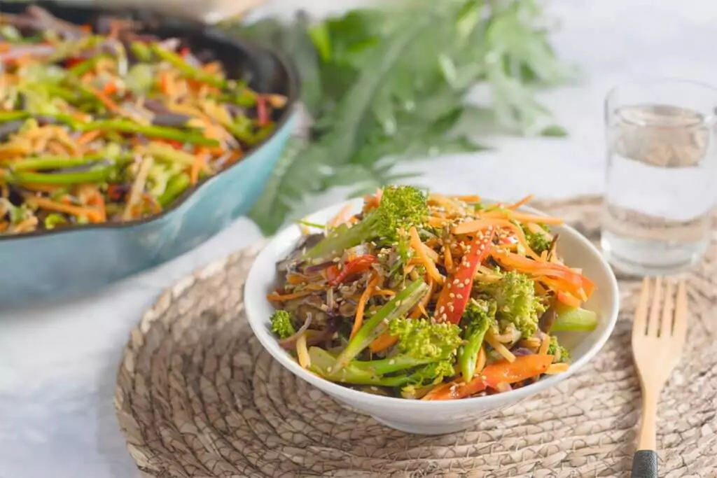 Eine Schüssel gefüllt mit einem köstlichen Keto-Gemüsemix in asiatischer Inspiration. Darauf sind verschiedene Gemüsesorten wie Möhren, Brokkoli und rote Paprika zu sehen.